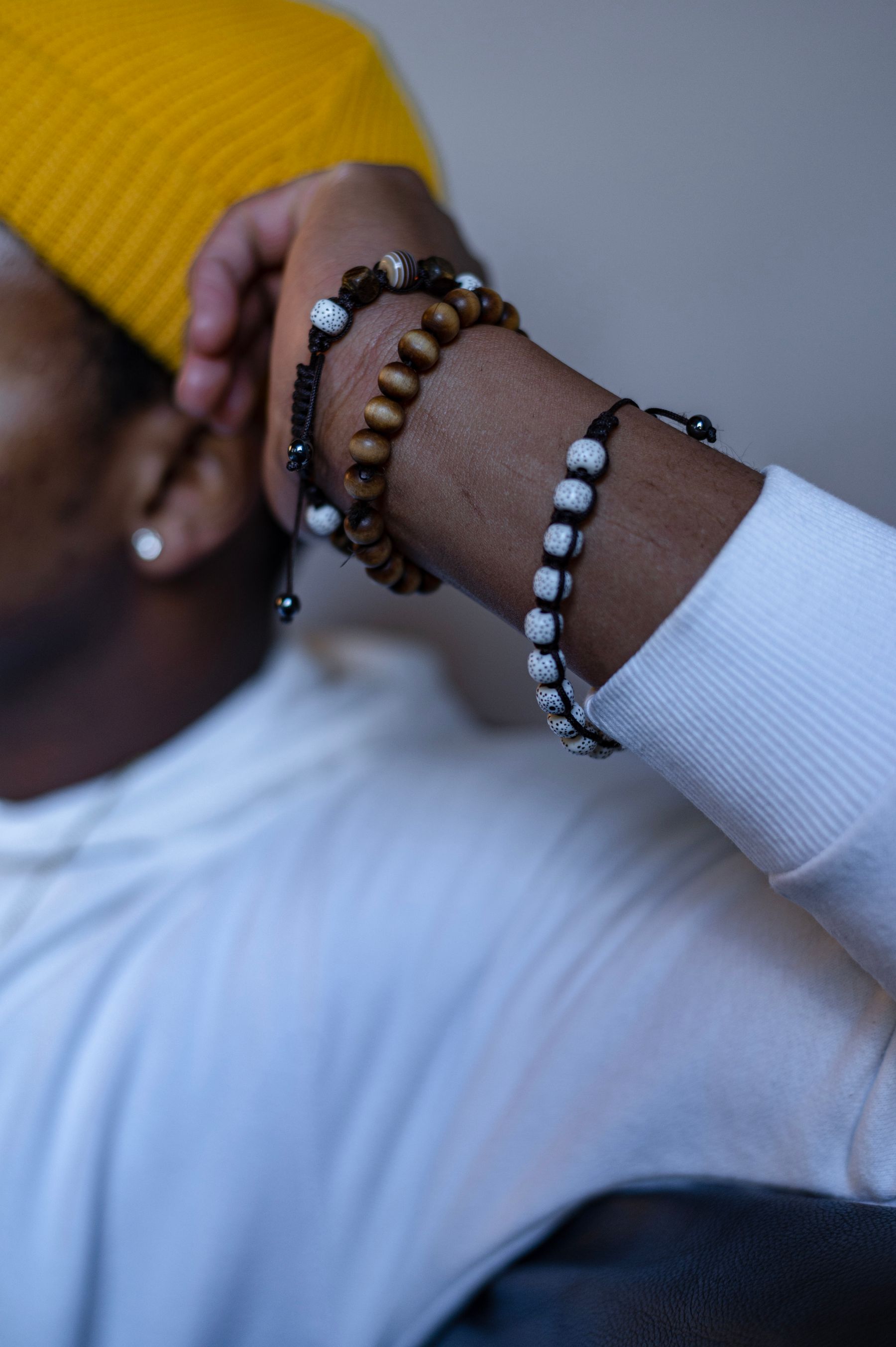 Person wearing warm brown and black bead bracelets